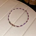 Primo piano di un elegante bracciale in zircone viola rettangolare in un portagioie beige - Argento-Viola