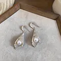 Close-up of French luxury silver hollow lace earrings with pearl detail - Earring Hooks / Silver