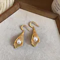 Detailed macro view of French light luxury gold earrings with hollow mesh design - Earring Hooks / Gold