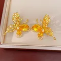 Close-up of gold-plated butterfly earrings with vibrant yellow zircon stones - Stud Earrings (Silver Pin) / Yellow
