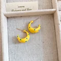 Detailed view of yellow C-shaped hoop earrings with blue polka dot enamel finish. - Stud Earrings / Silver Earring Post Style / Milk Yellow