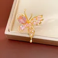 Close-up detail of a butterfly earring with pink zircons and gold plating. - Ring / Pink