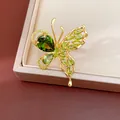 Detailed view of a gold-plated butterfly earring set with sparkling green zircons. - Ring / Green