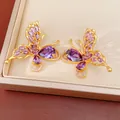 Detailed close-up of gold-plated butterfly stud earrings with sparkling purple CZ stones. - Stud Earrings (Silver Pin) / Purple