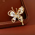 Detail shot of a gold-plated butterfly earring with sparkling cubic zirconia stones. - Ring / White