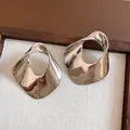 Detailed macro view of oversized geometric hollow silver earrings with a high-polished finish - Silver