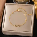 Dettaglio di un braccialetto infinito in oro con pietre di zircone su scatola - Bracciale Pavè Numero 8 (E2036) / Oro