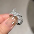 Detalle macro de un anillo de nudo plateado con pavé de brillantes circonitas cúbicas - Anillo Abierto Nudo Retorcido (HR762) / Plateado