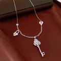 Exquisite silver key necklace with sparkling zircon stones and heart-shaped lock charms. - Silver