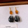Detailansicht von Retro-Resin-Ohrhängern mit schwarzem Marmor und Bernstein - Kaffee-Schwarz