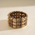 Detailed view of a bohemian three-row vintage gold stretch bracelet with rhinestones - Gold