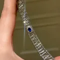 Macro detail of a silver open-work bracelet featuring a stunning central blue oval zircon. - Silver-Blue