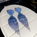 Close-up of blue gradient rhinestone tassel earrings with heart studs on a display box. - Heart Gradient Tassel Style (19#)