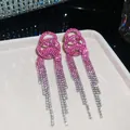 Detail view of pink and silver gradient rhinestone tassel earrings on a jewelry display tray - Circular Nested Long Tassel Style (24#)