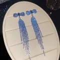 Elegant blue rhinestone bow-knot long tassel drop earrings showcased on display - Bowknot Rhinestone Tassel Style