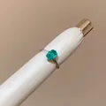 Close-up of a minimalist ring with a square green gemstone on a silver band. - Square Open Ring (HR3582) / Green