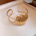 Detailed view of the gold metal pleated heart cuff bracelet with luxury aesthetic - Giant Heart Pleated Style / Gold