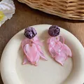 Detail view of elegant purple fabric rose and pink acrylic leaf tassel earrings on a tray - Silver Earring Post - Pink