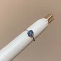 Close-up detail of a minimalist silver ring featuring a cushion-cut blue gemstone - Square Open Ring (HR3582) / Blue