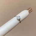 Close-up detail of a minimalist silver ring featuring a clear oval-cut gemstone. - Square Open Ring (HR3582) / White