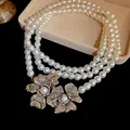 Close-up detail of retro multi-layer pearl necklace with sparkling crystal flower charms - Necklace / Gold-White