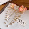 Dettaglio di ear cuff a fiori con lunghe nappe di perle su espositore - Stile a Gancio / Rosa con Bianco