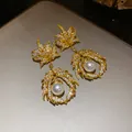 Detailed macro view of vintage gold earrings featuring zircon maple leaf and elegant pearl pendant - Maple Leaf Pendant Style (HE33229) / Gold