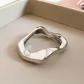 Macro view of a polished silver irregular wavy metal bangle with mirror finish. - Minimalist Cuff Wave Pleated Style / Silver