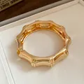 Detailed macro view of a gold-colored segmented metal bracelet featuring a polished mirror finish - Segmented Bamboo Mirror Style / Gold