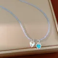 Detail view of a glass beaded necklace with silver heart and blue heart zircon charms. - Necklace - Silver - Blue