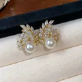 Detailed view of gold-plated wheat ear pearl earrings with cubic zirconia inlay - Gold