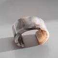 Primo piano del bracciale rigido in acrilico marmorizzato con finitura grigia lucida - Marrone Chiaro Marmorizzato