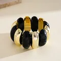Macro view of chunky contrast swirled black and gold geometric acrylic bracelet - Black