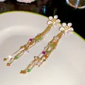 Close-up of elegant gold tassel earrings with white enamel flowers and colorful beads - White Flower Tassel (HE34240) / Silver Needle / Gold