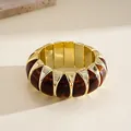 Close-up macro detail of a chunky geometric acrylic bracelet with gold accents and amber dye - Gold Deep Coffee