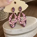 Detailed view of pink dripping oil and purple rhinestone hollow drop earrings on a stand - Hollow Marquise Drip Oil Style (HE33742) / Pink