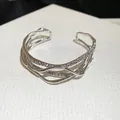 Elegant silver-colored metal cuff bracelet featuring intertwined rhinestone-encrusted bands. - Multi-Layer Wave Rhinestone Style / Silver