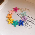 Macro view of bohemian multi-color raffia flower choker with adjustable gold chain - Bracelet / Gold-Multicolor