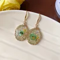 Detailed close-up of resin drop earrings with embedded green dried flowers - Hook Earring (HE31707) / Gold-White-Green