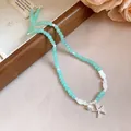 Détail d'un collier de perles turquoise avec étoile de mer pour les vacances d'été. - Collier-Bleu