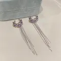 Close-up detail of purple stone ear cuffs with elegant long silver chain tassels. - Ear Cuffs / Silver-Purple