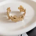 Elegant gold-toned open cuff bracelet featuring detailed textured floral pattern design. - Triple Pleated Flower Style / Gold