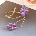 Close-up of gold spiral arm cuff with elegant purple enamel flowers - Purple