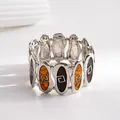 Macro detail of a vintage stretch bracelet featuring marbled resin and geometric engravings - Silver-Coffee-Yellow
