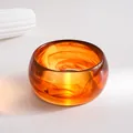 Macro view of translucent amber marbled resin bangle showing elegant swirl patterns - Coffee