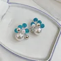 Close-up of elegant stud earrings with pearls and blue faceted beads in a jewelry box - Silver Pin (Silver) / Blue