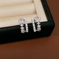 Detail view of silver double-layer butterfly earrings with inlaid pearls and zircons - Silver Post Butterfly C-Shaped Style / Silver-White