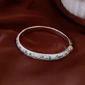 Detailed close-up of a silver bangle inlaid with mint green and clear zircon stones. - Silver with Mint Blue