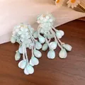 Detailansicht der mintgrünen Blumenperlen-Quastenohrringe mit schönen Tropfenanhängern - Silber-Ohrstecker-Stil / Blau