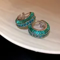 Dettaglio ravvicinato di orecchini a cerchio a C con zirconi verde smeraldo e tondi - Argento-Verde